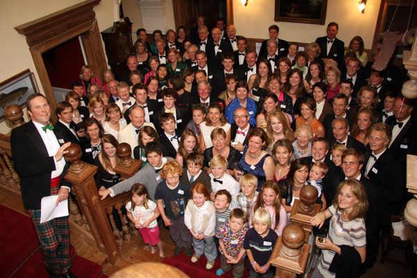 group photo of over 100 guests at a dinner party